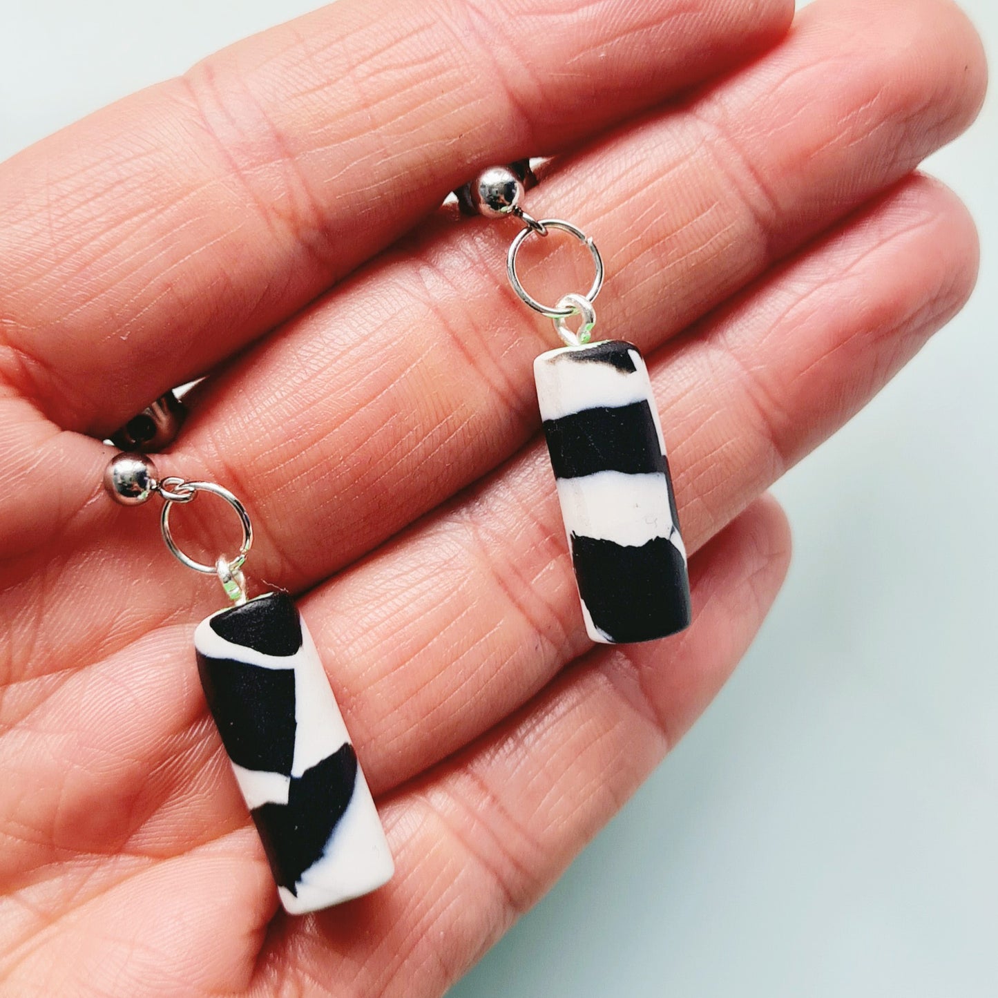 Black & white spotted cylinder dangle earrings